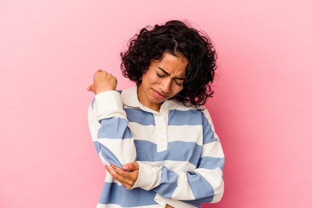 Joven Mujer Latina Rizada Aislada Sobre Fondo Rosa Masajeando El Codo