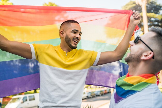 Pareja Gay Abrazando Y Mostrando Su Amor Con La Bandera Del Arco Iris