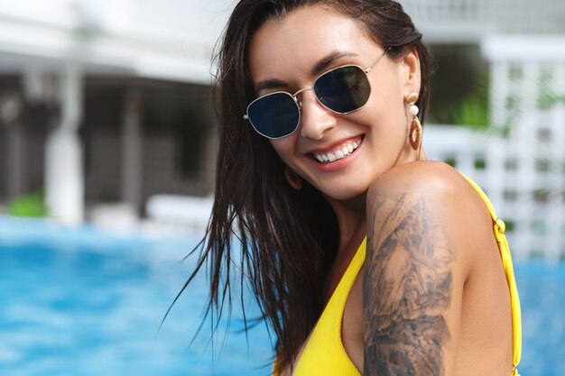 Primer Plano De Hermosa Mujer Curtida Con Tatuaje En Bikini Amarillo