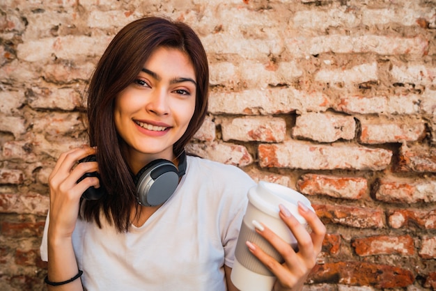 Retrato De Joven Mujer Latina Con Auriculares Contra La Pared De