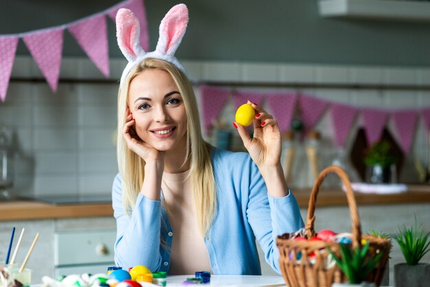 Premium Photo Attractive Blonde Puts Easter Eggs In Easter Basket