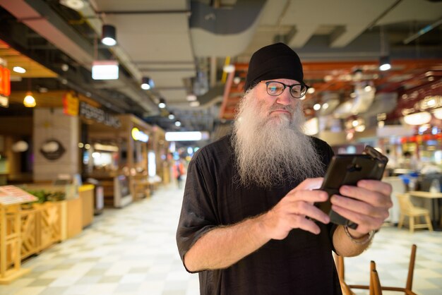 Premium Photo Mature Bearded Hipster Man Using Phone With Eyeglasses