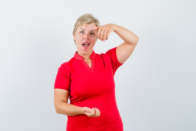 Free Photo Mature Woman Pretending To Hold Or Show Something In Red T