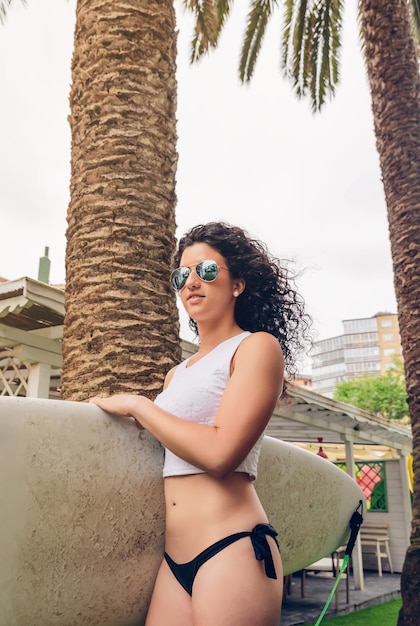 Premium Photo Portrait Of Curly Brunette Surfer Woman With White Top