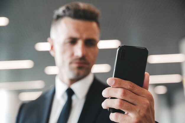 Premium Photo Serious Mature Businessman Looking At Mobile Phone