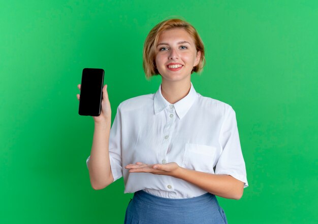 Jeune Fille Russe Blonde Souriante Tient Et Pointe Avec La Main Au