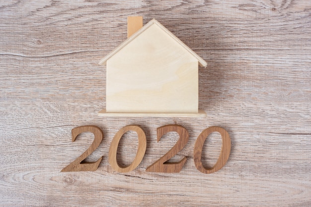 2020 szczęśliwego nowego roku z modelu domu na stole z drewna Premium Zdjęcia