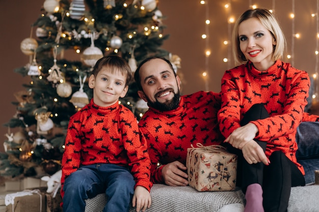 Atrakcyjni Rodzice I Ich Synek W Czerwonych Swetrach Bawią Się Przed świętami Darmowe Zdjęcia