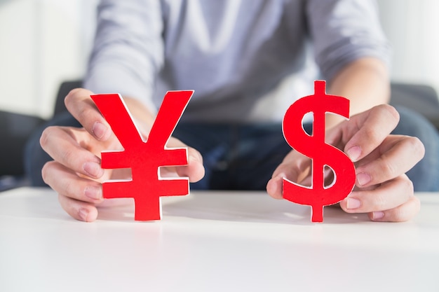 Biznesmen gospodarstwa znak dolara i znak cny Darmowe Zdjęcia
