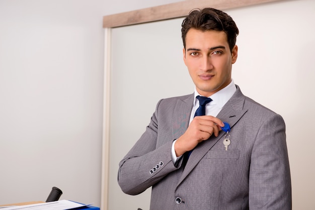 Biznesmen w nieruchomości pojęciu z domowym kluczem Premium Zdjęcia