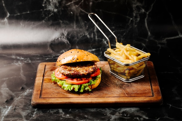 Burger z mięsem, pomidorem i sałatą podawany z frytkami. Darmowe Zdjęcia