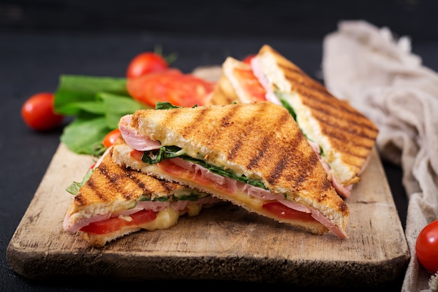 Club sandwich panini z szynką, pomidorem, serem i bazylią. Premium Zdjęcia