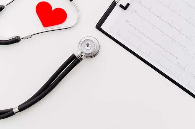 Czerwony serce z stetoskopem blisko ecg raportu medycznego na białym tle Darmowe Zdjęcia