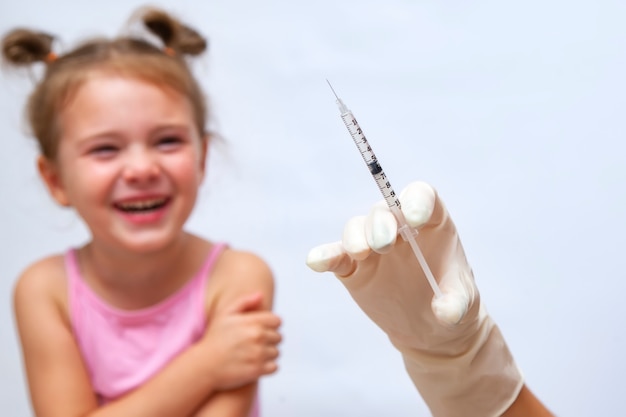 Doktor podający dziewczynie szczepionkę iniekcyjną. Premium Zdjęcia