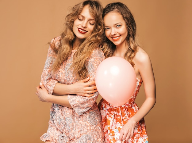 Dwie Uśmiechnięte Piękne Kobiety W Letnich Sukienkach. Girls Posing. Modele Z Kolorowymi Balonami. Zabawy, Gotowe Na Uroczystości Urodzinowe Lub Przyjęcie świąteczne Darmowe Zdjęcia