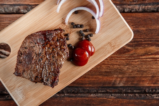 Grillowane Mięso Z Przyprawami I Sosem Pomidorowym Na Przetartym Drewnianym Tle Premium Zdjęcia