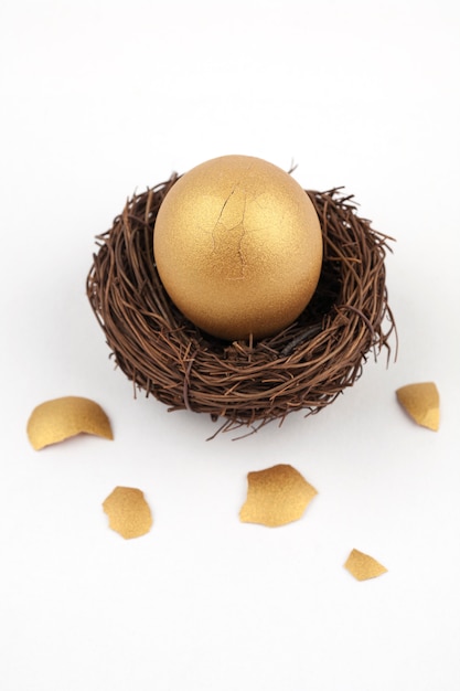 Krakingowy Złoty Jajko Na Białym Tle Premium Zdjęcia