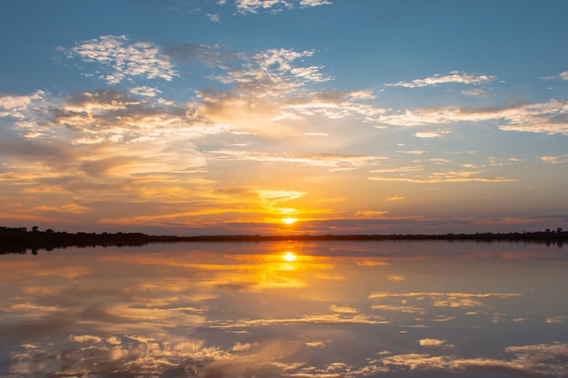 Laguna Refleksji Słońca. Piękny Zachód Słońca Za Chmurami I Błękitne Niebo Nad Krajobrazem Laguny. Dramatyczne Niebo Z Chmurą O Zachodzie Słońca Premium Zdjęcia