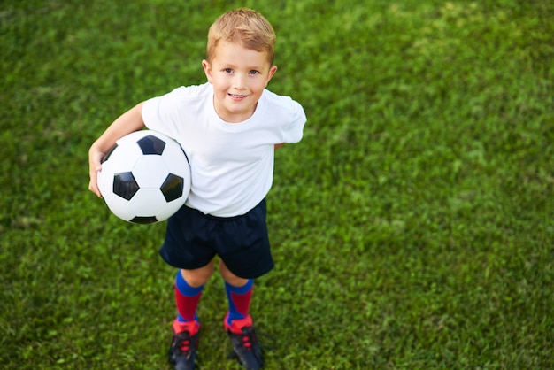 Little boy ćwiczy piłkę nożną na świeżym powietrzu Premium Zdjęcia