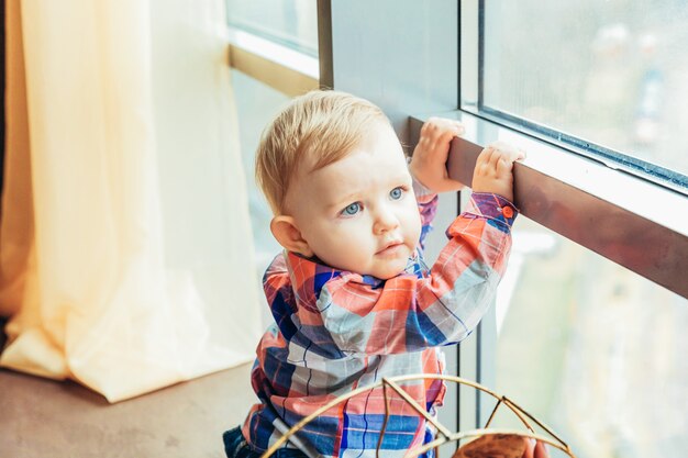 Mały śliczny niemowlak blisko dużego okno Premium Zdjęcia