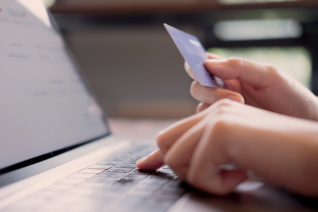 Płatności online, ręce kobiety trzymającej smartfon i przy użyciu karty kredytowej do zakupów online. Premium Zdjęcia