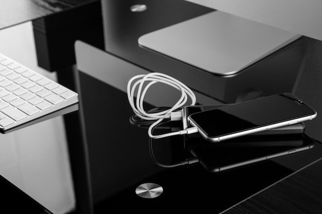Power bank ładuje smartfon na eleganckim czarnym stole Premium Zdjęcia