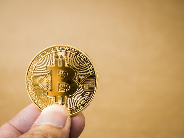 Ręka trzyma złoty bitcoin. Premium Zdjęcia