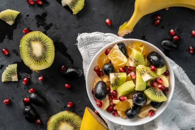 Sałatka Owocowa Z Tropikalnymi Egzotycznymi Dojrzałymi Owocami Pokrojonymi W Kostkę, Pomarańczą, Kiwi, Bananem, Winogronami, Granatami Premium Zdjęcia