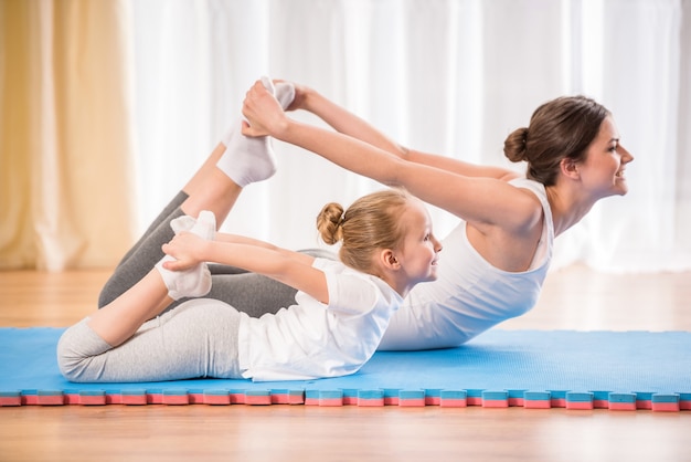 Sportowa matka i córka robi ćwiczenia jogi. Premium Zdjęcia