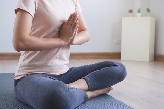 Styl życia jogi i medytacji. bliska widok młodej pięknej kobiety praktykowania jogi namaste stanowią w salonie w domu. Premium Zdjęcia