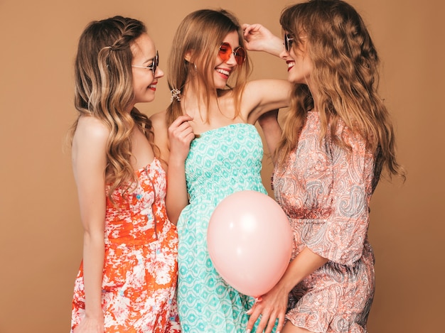 Trzy Uśmiechnięte Piękne Kobiety W Letnich Sukienkach. Girls Posing. Modele Z Kolorowymi Balonami. Zabawy, Gotowe Na Uroczystości Urodzinowe Lub Przyjęcie świąteczne Darmowe Zdjęcia
