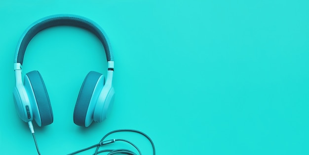 Turkusowe słuchawki na kolorowym tle. koncepcja muzyki z copyspace Premium Zdjęcia