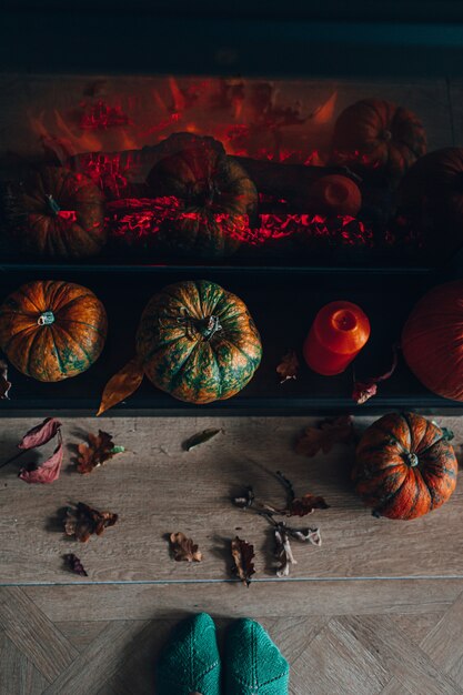 Widok Z Góry Na Kominek Ozdobiony Dyniami I Suchymi Jesiennymi Liśćmi Oraz Pomarańczową świecą. Przytulny Dom Koncepcja. Przygotowanie Do Halloween. Premium Zdjęcia