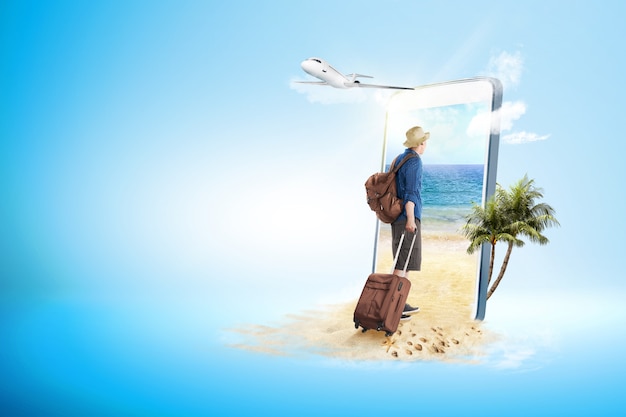 Widok z tyłu azjatycki człowiek w kapeluszu z walizką i plecak spacery na plażę Premium Zdjęcia