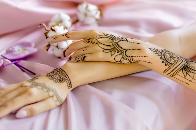 Zblizenie Smukle Zenskie Nadgarstki Malowane Tradycyjnymi Indyjskimi Ornamentami Mehndi Orientalne Damskie Dlonie Ozdobione Tatuazem Z Henny Jasnorozowy Material Z Zakladkami Na Tle Bawelniane Kwiaty Zdjecie Premium