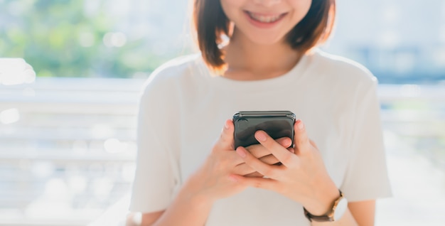 Zbliżenie trzyma smartphone kobieta, wyśmiewa up pusty ekran. za pomocą telefonu komórkowego na styl życia. technologia dla koncepcji komunikacji. Premium Zdjęcia