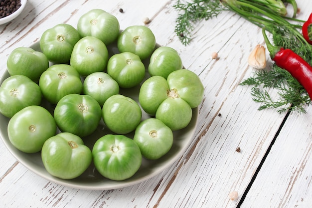 Zielone pomidory, pikle na białym drewnianym stole z zieloną i czerwoną i papryką chili, koper włoski, sól, czarne pieprzu, czosnek, groch, z bliska, zdrowe pojęcie, widok z góry, płaskie świeckich Darmowe Zdjęcia