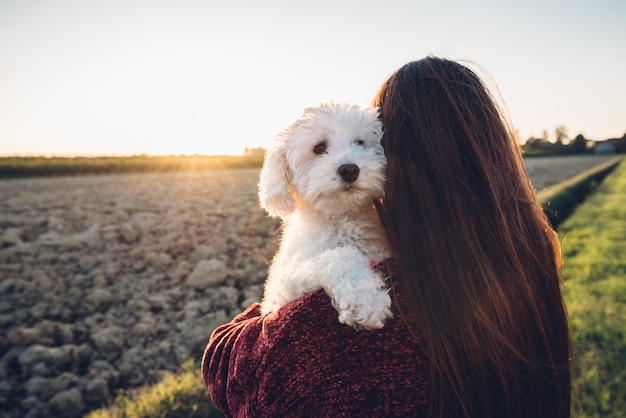 Abrazo romántico entre un perro blanco y su dueño. humanos y animales  enamorados | Foto Premium