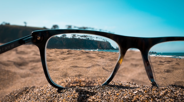 Acercamiento De La Playa Vista Desde Las Lentes De Gafas Negras Foto Gratis