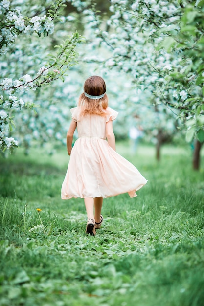 Adorable niña en jardín floreciente de manzano en primavera | Foto ...