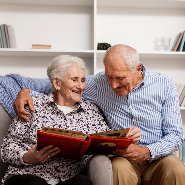 Adorable Pareja De Ancianos Mirando El álbum De Fotos Foto Gratis 