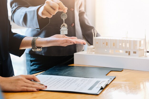 Agente inmobiliario que entrega las llaves de la casa al hombre y firma ...