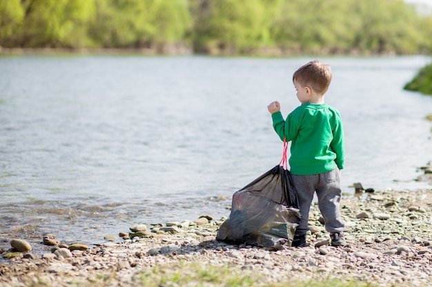 Ahorre El Concepto De Medio Ambiente Un Niño Que Recoge Basura Y Botellas De Plástico En La 0274