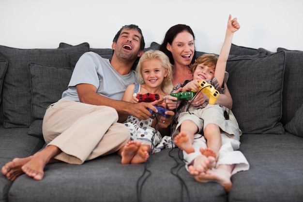Alegre familia jugando videojuegos en casa | Foto Premium
