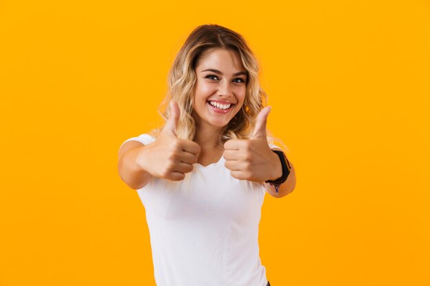 Alegre Mujer Rubia En Ropa Básica Sonriendo Y Mostrando Los Pulgares Hacia Arriba Aislado Sobre 1591