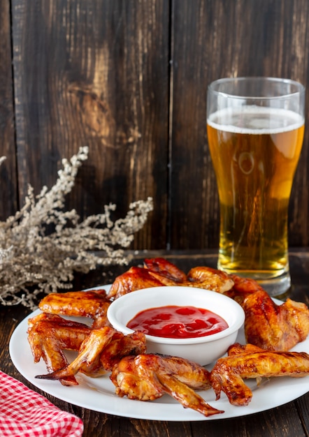 Alitas De Pollo A La Parrilla Con Cerveza Y Salsa Roja Sobre Un Fondo De Madera Merienda A La Cerveza Parilla Recetas Foto Premium