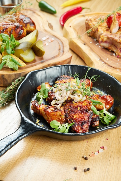 Alitas De Pollo A La Parrilla En Salsa De Miel Y Cerveza Servidas En Una Sarten Decorativa Con Hierbas De Cerca Enfoque Selectivo Pared De Madera Foto De Comida Foto Premium