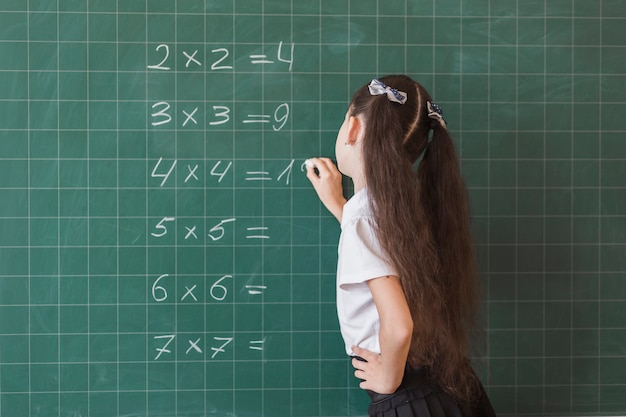 Alumno Haciendo Ejercicio De Matemáticas En La Pizarra Foto Gratis