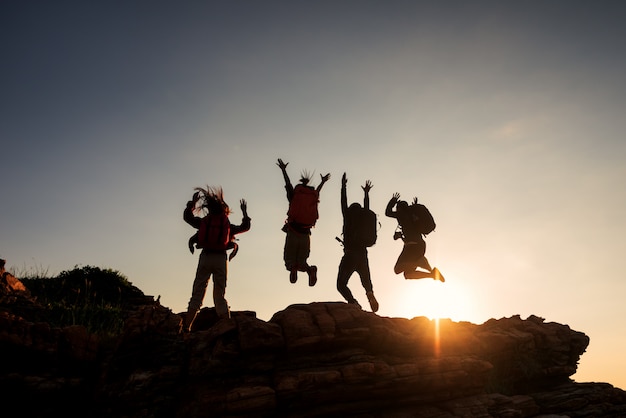 Amigos Del Grupo De Escalada Saltando En La Montaña Superior Y El Increíble Cielo Al Atardecer 