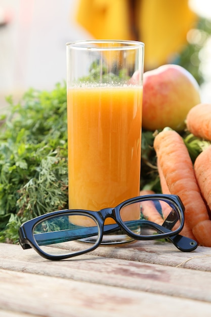 Anteojos Y Un Vaso De Jugo Fresco De Zanahoria Y Manzana Foto Premium